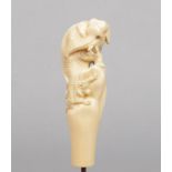 A Japanese Meiji period ivory cane handle. Carved to depict a pair of tigers and a lion, ivory