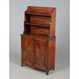 A Regency mahogany waterfall bookcase of small proportions. With panelled doors and raised on