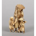 A Japanese Meiji period carved ivory okimono. Formed as a man wearing a coolie hat, with a basket on
