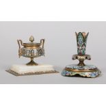 An early 20th century French bronze and alabaster inkwell with champleve enamel decoration and a