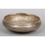 A large Indian silver bowl with repousse decoration of scrolling foliage and butterflies, 34cm