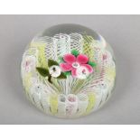 A Paul Ysart glass paperweight decorated with a single flower over a white and yellow stave