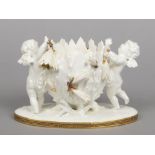 A Moore Brothers figural centrepiece. Formed as a pair of cherubs either side of an oversized seed