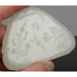 A Chinese carved pale celadon jade chime of triangular form. Decorated in shallow relief with a