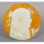 A Leeds Art Pottery circular cameo portrait plaque. Depicting the head of Cleopatra in profile