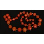 A string of vintage amber coloured graduating spherical beads, largest 17mm.