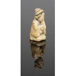 A Japanese Meiji period carved ivory miniature okimono. Formed as a kneeling maiden holding a