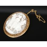 A 9 carat gold mounted carved shell cameo brooch. With ropetwist border and depicting the three