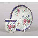 A Worcester fluted coffee cup and saucer. Decorated in coloured enamels with flowers under a blue
