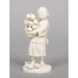 A Japanese Tokyo school ivory okimono. Carved in the form of a boy holding a basket of