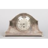 A George V mantel clock in silver plated and planished case. With a silvered dial and housing a