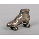 An Edwardian novelty silver pin cushion formed as a roller skate and with working wheels. Assayed
