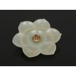 A silver mounted carved celadon jade brooch formed as a lotus flower, 4.75cm wide.