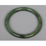 A Chinese mottled spinach jade bangle, 76mm outer diameter.