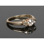 An 18 carat gold three stone diamond ring. Old European cut the centre stone approximately 0.8ct,