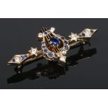 A Victorian 15 carat gold, sapphire and diamond bar brooch. Surmounted by a lyre flanked by a pair