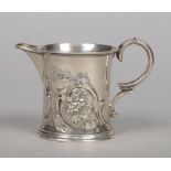A Victorian silver cream jug by Edward Ker Reid. Chashed with leaves and scrolls and with double