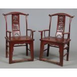 A pair of Chinese hardwood yolk crested armchairs. Each with a pierced splat decorated with