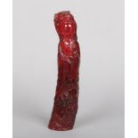 A Chinese carved cherry amber coloured statue of Guanyin. Dressed in flowing robes and holding a