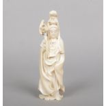 A Japanese Meiji period carved ivory okimono. Formed as Guanyin dressed in a flowing robe and