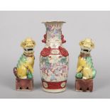 A pair of 20th century Chinese lion dogs raised on rectangular plinths and coloured in enamels along