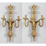 A pair of 18th century Continental giltwood and gesso three branch wall sconces. With urn finials,