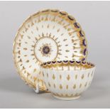 A Worcester fluted teabowl and saucer. Painted with a border of blue peacock eyes and with gilt