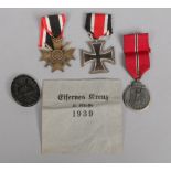 Three World War II German Third Reich medals and a badge. Iron Cross, War Merit Cross and Eastern
