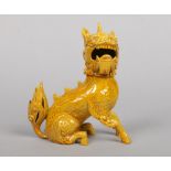 A Burmantofts Faience model of a seated Kirin decorated in yellow glaze. Impressed mark, model