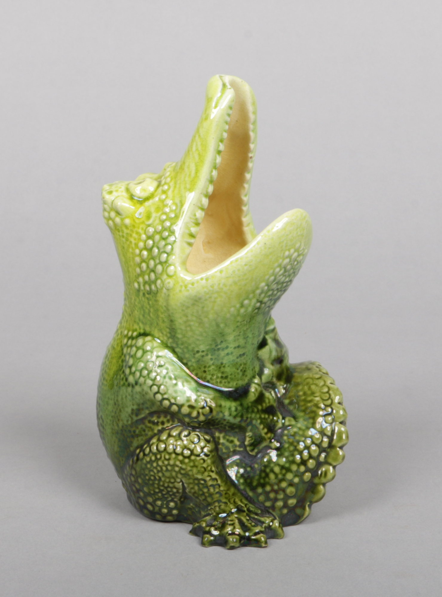 A Burmantofts Faience model of a grotesque crocodile. Modelled in seated pose with a gaping mouth