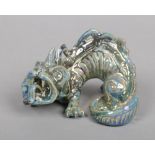 A Burmantofts Faience grotesque model of a dragon decorated in a blue lustre glaze. Impressed marks,