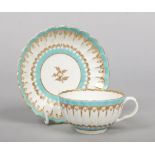 A Worcester fluted teacup and saucer. Painted with turquoise and gilt borders c.1775, saucer 13.