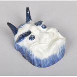 A Japanese blue and white porcelain brush washer. Formed as a noh mask and painted in underglaze
