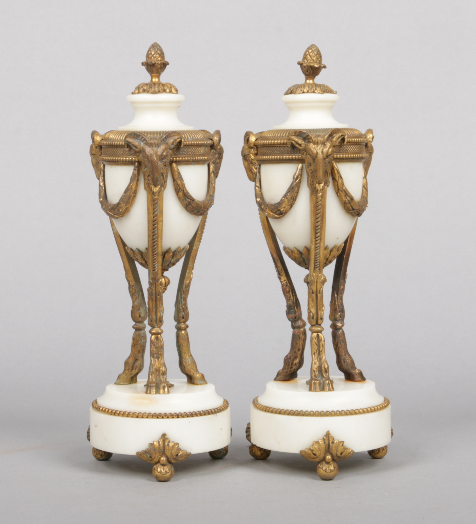 A pair of French Neo-Classical alabaster and gilt metal mantel urns. With acorn finials and