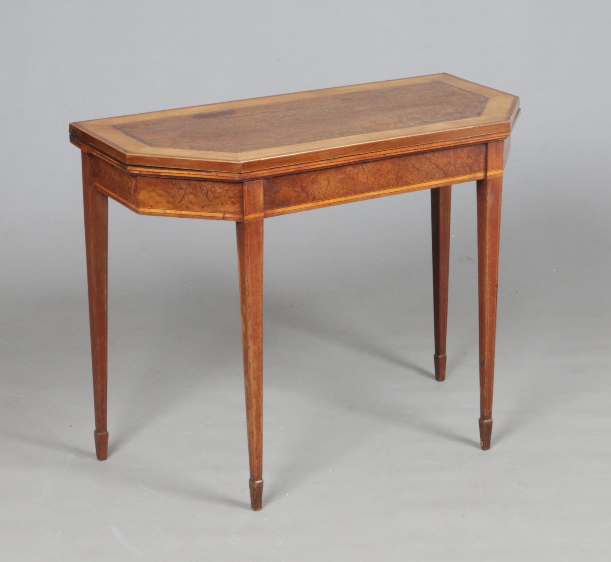 A Regency burr yew wood fold over card table crossbanded in satinwood. With canted corners and