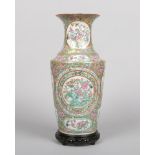 A 19th century Cantonese vase on hardwood plinth. Gilt ground with fruit, flowers and butterflies