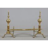 A pair of mid 19th century brass fire dogs and guard rail, 108cm wide.