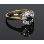 An 18 carat gold sapphire and diamond cluster ring. Size K 1/2.