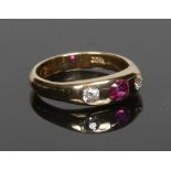 An 18 carat gold ruby and diamond ring with rub over set stones. Size N.