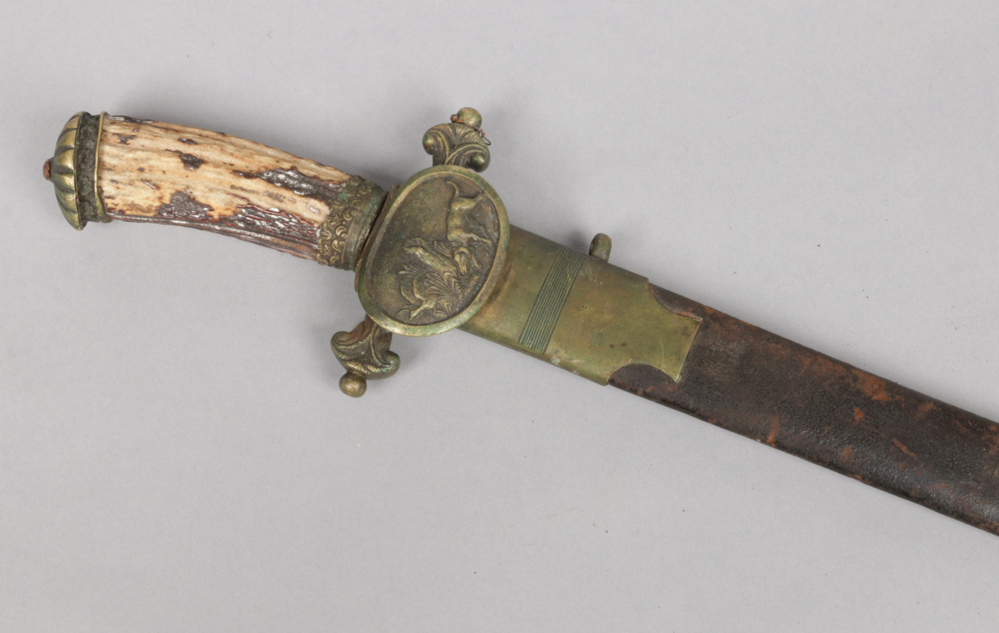 A 19th century German hunting sword with brass and leather scabbard. With antler grip and cross