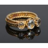 An 18 carat gold three stone aquamarine ring on ropework shank. 5.6 grams, size O.