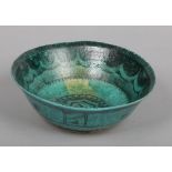 An antique Persian pottery bowl. Green glazed and with stylized penwork decoration, 21.5cm