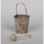 A Chinese silver ice bucket with swing handle, drainer and tongues. Planished and engraved with a
