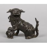 A Chinese Ming dynasty bronze model of a lion dog with a brocade ball, 9.75cm.