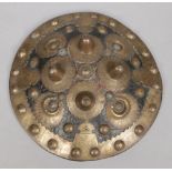 A 19th century Indo-Persian small roundel shield clad in leather and brass, 28cm diameter.