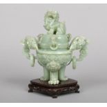 A 20th century Chinese hardstone jade coloured censor and cover on hardwood stand. Carved with a