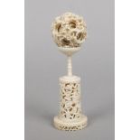 An early 20th century Cantonese carved ivory eight piece puzzle ball on stand. The stand is