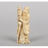 A Japanese Meiji period small ivory okimono. Carved in the form of an elderly bearded man dressed in