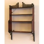 A 19th century mahogany four tier wall shelf with open fret carved pediment, 78cm.