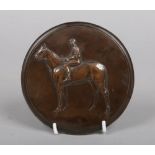 A 19th century bronze roundel equestrian plaque decorated in relief with a mounted jockey, signed P.